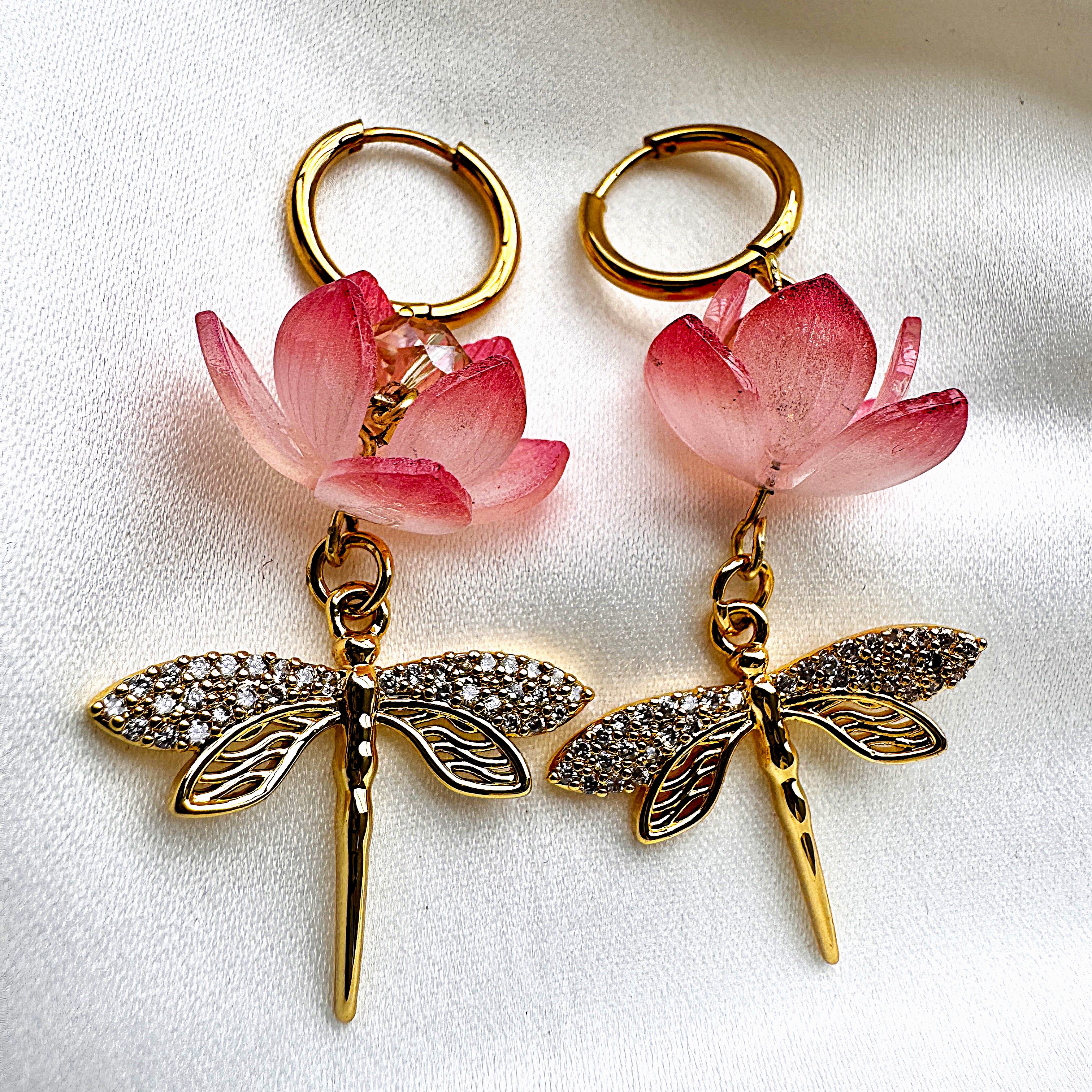 A Lotuswing earring showing a blooming lotus suspended above a jewelled dragonfly.