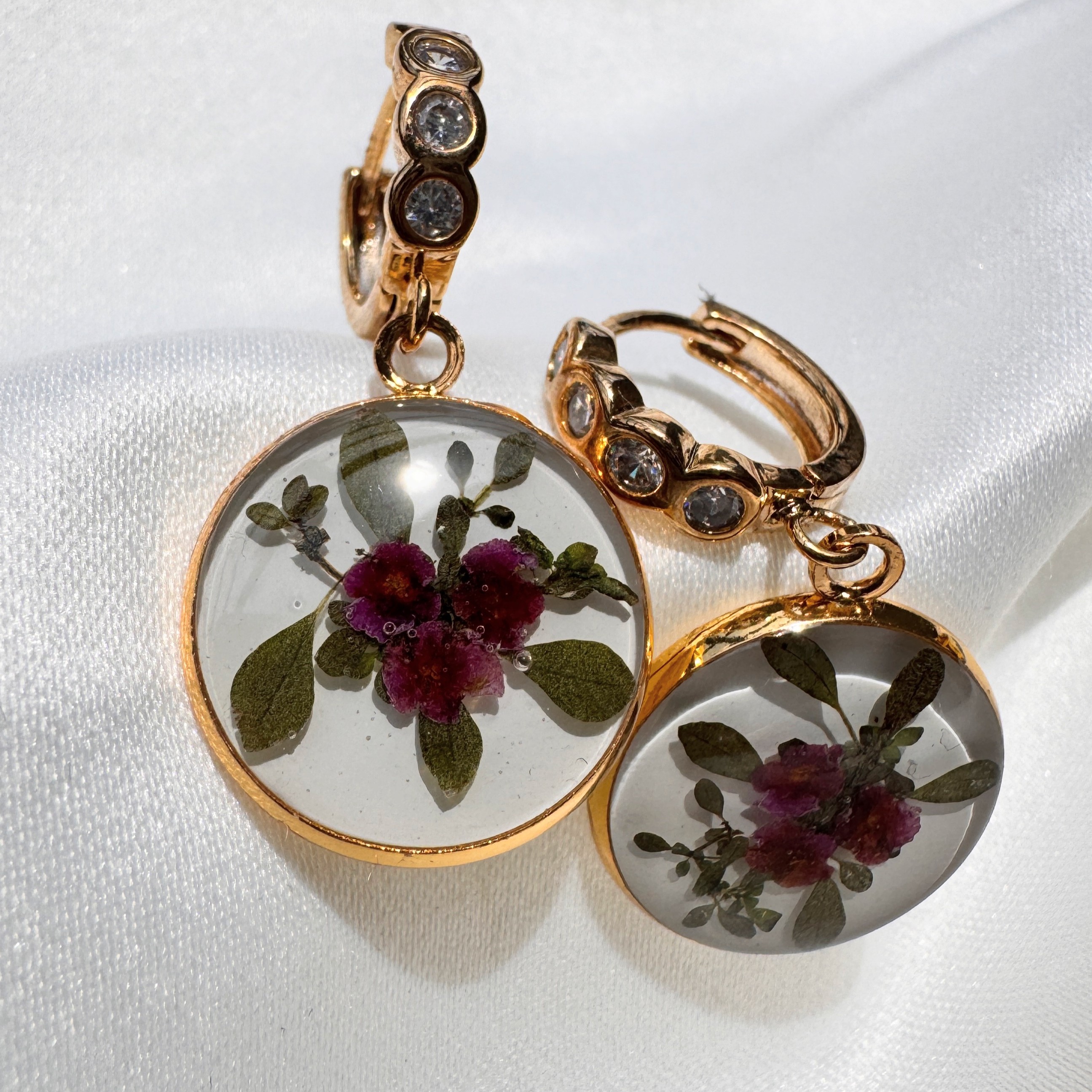 Circle of Grace hoop earrings with deep pink flowers in a resin medallion and crystal accents.