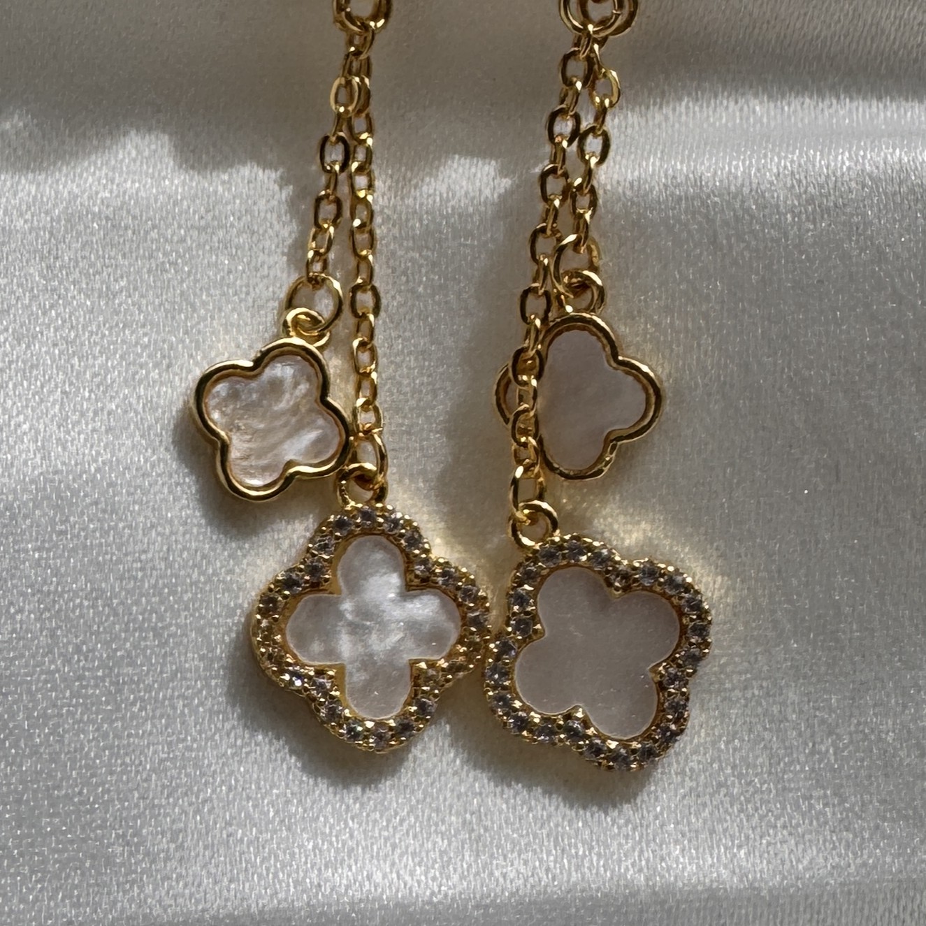 Clover Charm dangle earrings with mother of pearl florals and crystal accents on a gold chain.