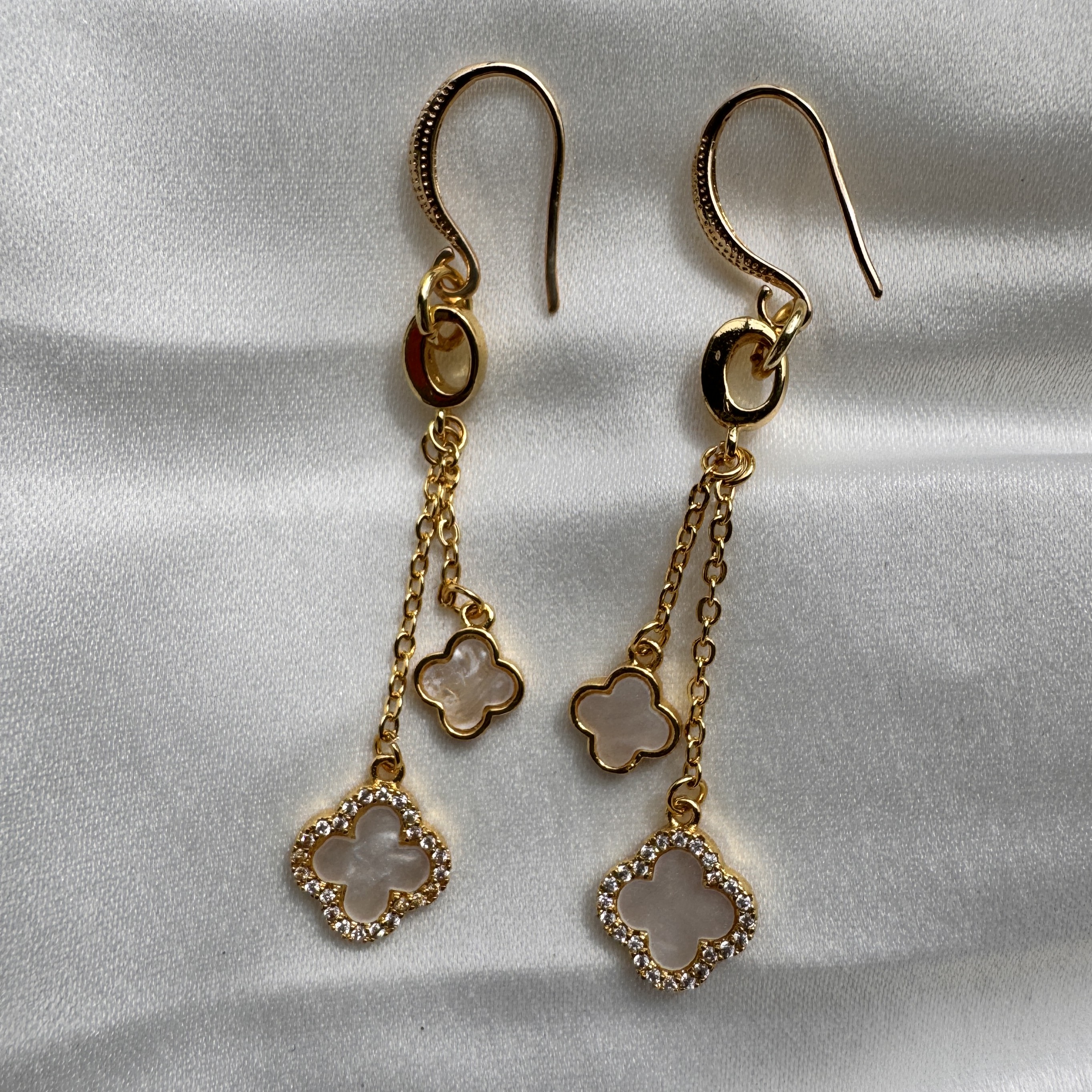 Clover Charm dangle earrings with mother of pearl florals and crystal accents on a gold chain.