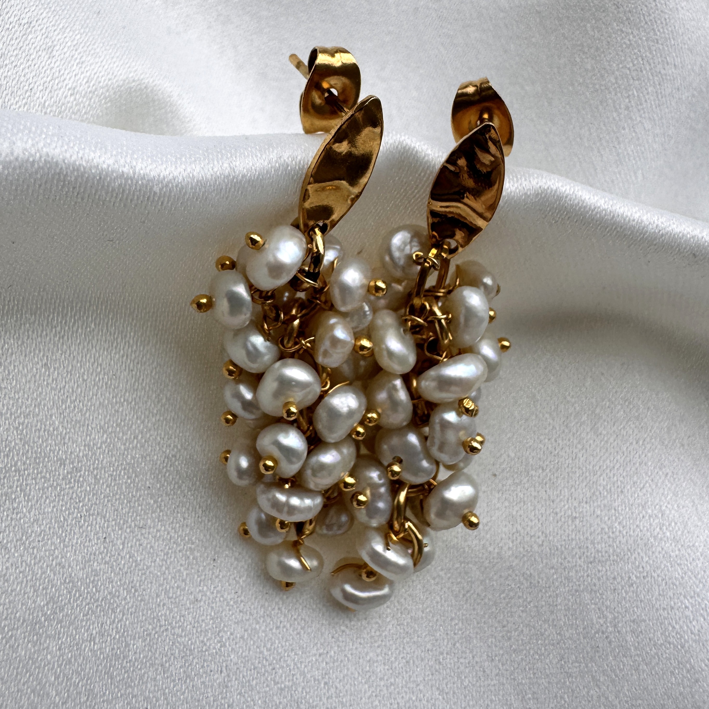 A pair of Pearl Bouquet earrings with a lush cluster of freshwater pearls on a gold setting.