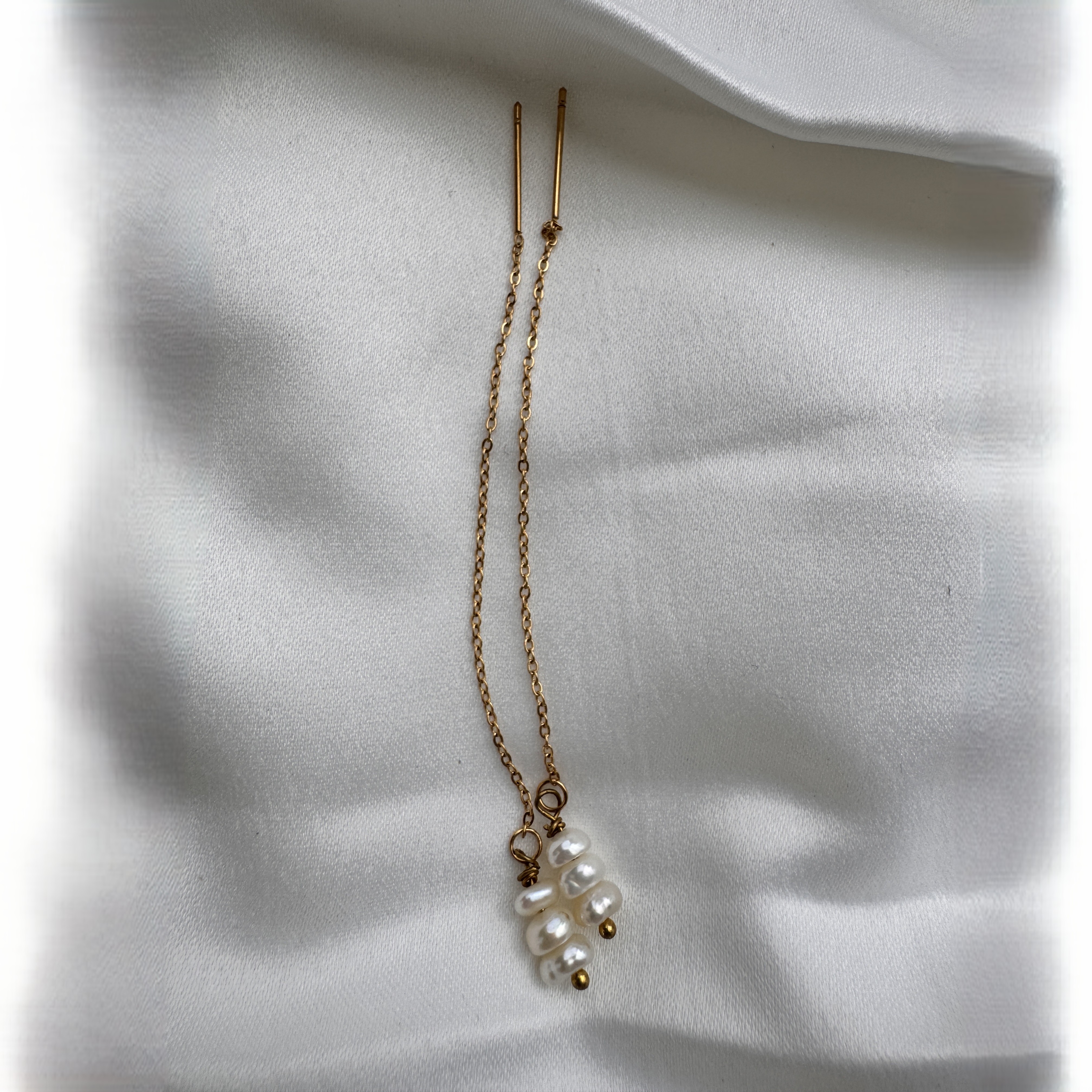 A pair of Pearl Stack threader earrings with a small stack of freshwater pearls.